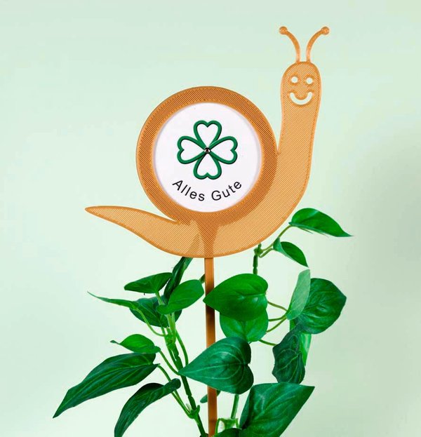 Blumenstecker zum selbst gestalten-Motiv Schnecke hellbraun mit Fotoaufkleber "Alles Gute"-Dekorationsbeispiel mit Grünpflanze-Blumenstecker aus recyceltem Kunststoff