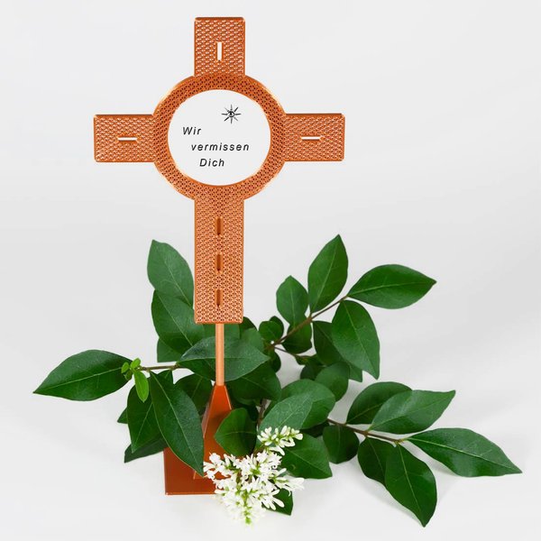 Blumenstecker Kreuz kupferfarben mit einem Aufkleber und dem Schriftzug Ich vermisse Dich"-dekoriert mit weißen Blüten und grünen Blättern